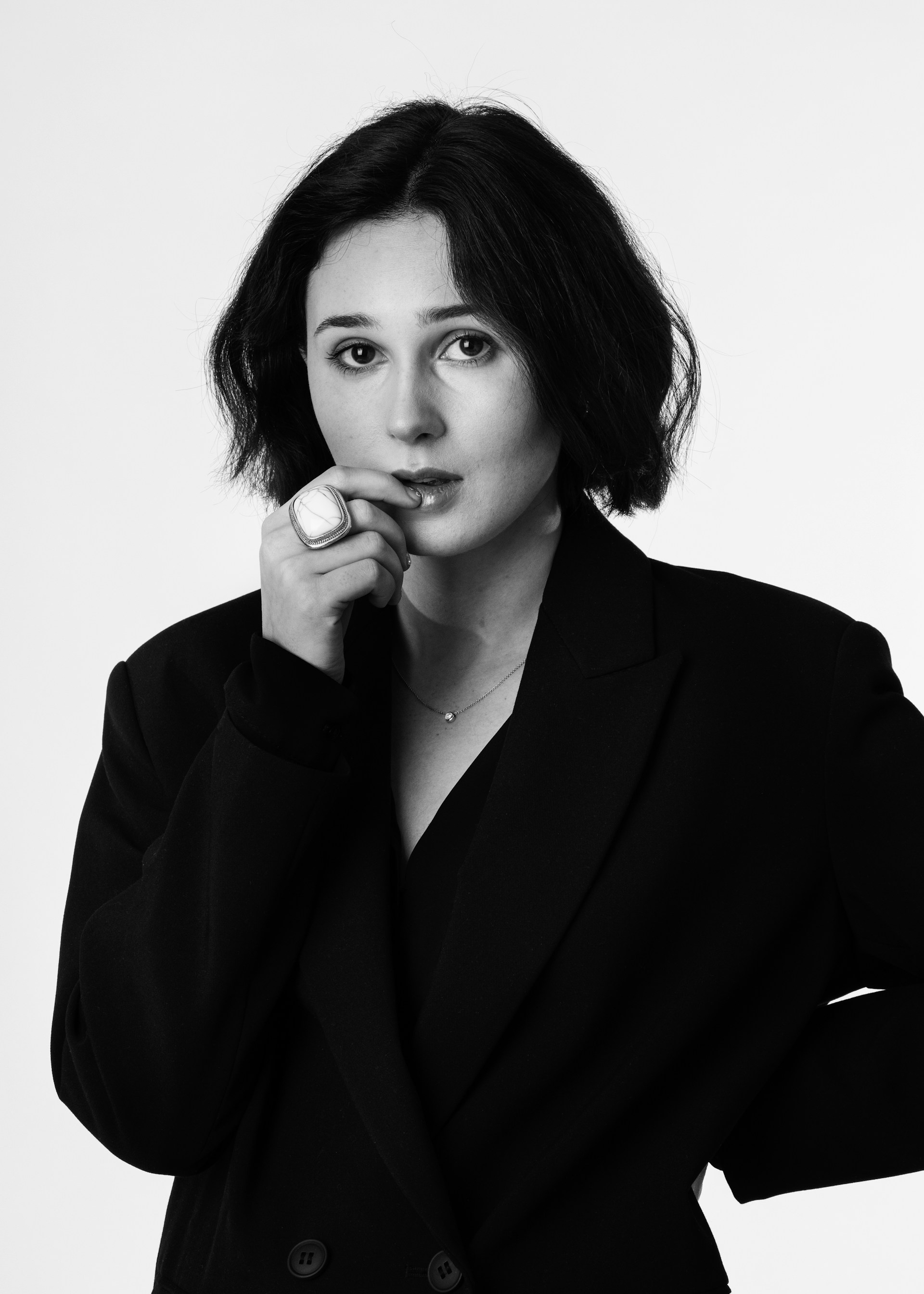 A black-and-white portrait of a woman wearing a black suit jacket