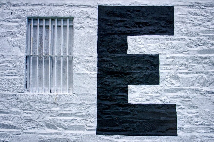 Photo of the site of a building painted white with a large uppercase E painted on it